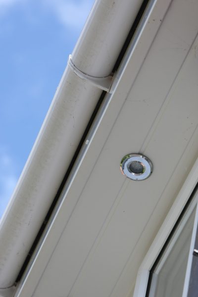 Close-up of white soffits and guttering with an embedded LED spotlight