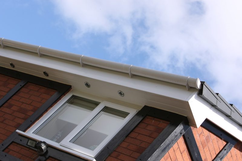 Close-up of white fascias, soffits and guttering with embedded LED spotlights